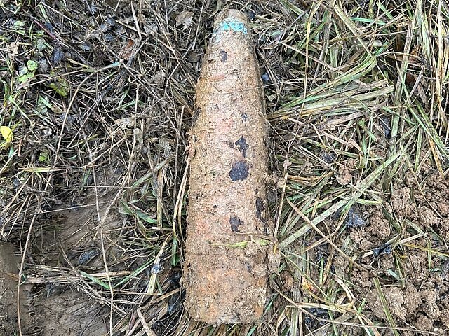 A brown grenade that was unearthed from the ground.