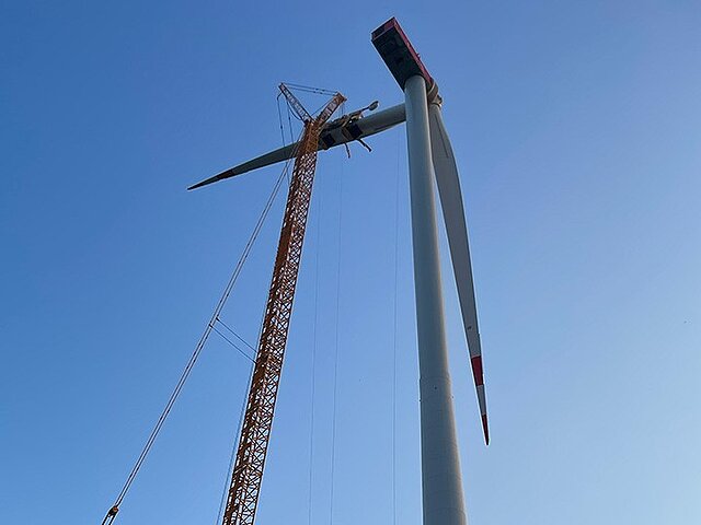 Fitting the rotor blades to a wind turbine.