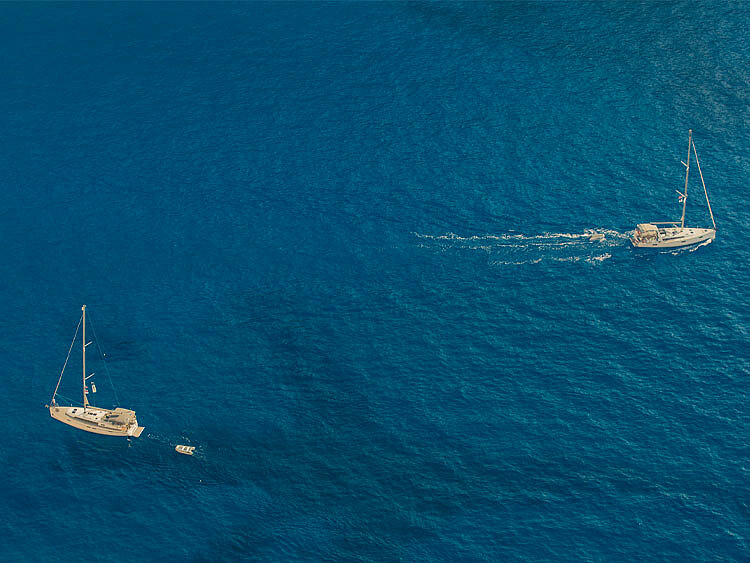 Two boats seen from above drifting on a calm ocean.