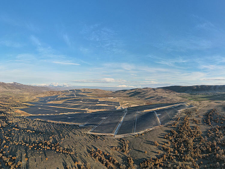 A large wind farm stretches along the hills to the horizon.